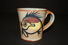 Hand-turned with an attached handle, the piece was made at the central  Florida coastal Merritt Island Pottery. This painted fish mug is not a  unique piece, but is a design that was