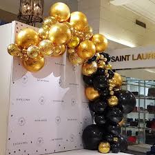 Black And Gold Backdrop With Balloons Stunning Example Of Metallic Gold Integrating With Onyx Black To Celebrate 180 Years Of Davidjones Black And Gold Balloons Balloon Pillars Balloon Decorations