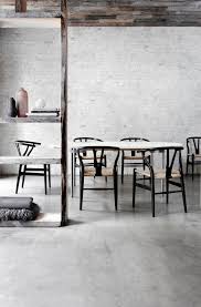 Hans wagner wishbone chairs sit at a black oval dining table lit by a modern chandelier and positioned in front of a plank bookcase. Ch24 Wishbone Chair Y Chair Carl Hansen Son Beech Soaped Carl Hansen Ch24 Buche Geseift