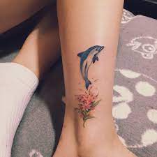 Your dolphins are simple & beautifull! Gray Dolphin Tattoo With Flower On Leg