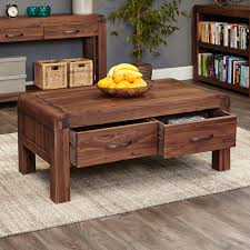 A coffee table is another living room essential, even if you never touch the stuff. Shiro Walnut Four Drawer Coffee Table Wooden Furniture Store