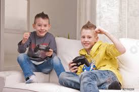 Niños jugando videojuegos mientras se está acostado. Dos Ninos Jugando Videojuegos Foto De Stock Crushpixel