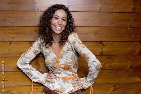 Ritratto di ragazza afroamericana ispirata alla calma toccare il palmo del petto credere che i sentimenti abbiano un bell'aspetto grato indossare vestiti eleganti di lucentezza verde isolati su sfondo di colore giallo. Ragazza Allegra Con I Capelli Ricci Stock Foto Adobe Stock