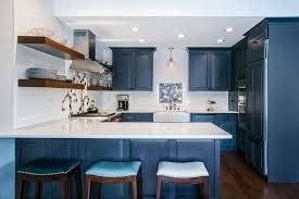 A Blue Kitchen With White Walls Floating Shelves And Dark Wood Flooring Wood Floor Kitchen Kitchen Inspiration Design Dark Wood Kitchens