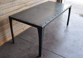 The straight legs, thin poles underneath the table, and riveted metal accents on the sides all add to the rustic design. Simple Metal Table Vintage Industrial Furniture