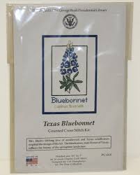 A counted cross stitch pattern of a field covered in flowering bluebonnets, with a few yellow flowers scattered here and there. Bluebonnet Cross Stitch Kit The George Bush Museum Store