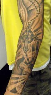 Green and black celtic cross tattoo on man left half sleeve. 35 Christian Tattoos On Full Sleeve