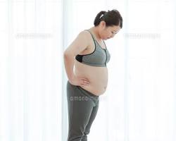 体重計に乗る中高年女性の画像