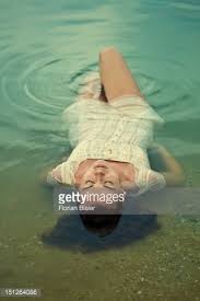 Your summer staples this year will probably include at least one floaty white dress and a perfect pair of white jeans. Woman Lying On Her Back In Wet White Dress At Beach Wet Dress Photoshoot Inspiration Photos Of Women
