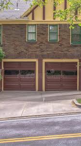 As a general rule, most garage manufacturers in the united states refer to their standard 18' to 24' wide units as two car garages they are not. Vertical Two Car Garage With Glass Panes On Door Of A House With Brick Exterior Wall Stock Image Image Of House Garage 168773317