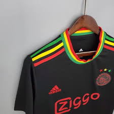 The black strip, which features red, yellow and green details and has three little birds just below the collar on the back of the shirt, is a . Ajax Amsterdam Third Bob Marley Trikot