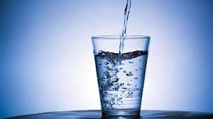 Woman drinking water at home and looking at you sitting on a couch in the living room at home. Drinking Water Free 1600x900 Wallpaper Teahub Io