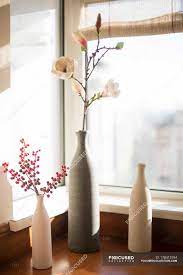 Pillow, sofa and flower vase beside window. Vases With Flowers On Window Sill Daylight Style Stock Photo 178415194
