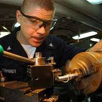 Machinery Repairman 3rd Class Anthony Gerhardt creates a guide pin for  support equipment using a lathe in the machine shop aboard Nimitz-class  aircraft carrier USS John C. Stennis (CVN 74).