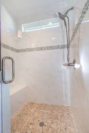 Master Shower With Pebbles On The Floor And Glass Accent Band With Mirasol Carrera Tile Custom Tile Shower Marble Showers Master Shower