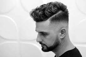 The sides are slightly shorter, and the top shows off the curls: Short Curly Hair For Men 50 Dapper Hairstyles