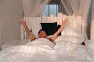 lazy man stretching after wakup in bed 8029817 Stock Photo at Vecteezy
