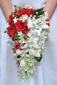 A bouquet woven from phalaenopsis orchids is trimmed with stephanotis that flow to the ground. Rosa Bride 5 Fresh Touch Red Rose And White Orchid Cascade Bridal Bouquet With Stepha Bridal Bouquet Flowers Red Rose Bridal Bouquet Flower Bouquet Wedding