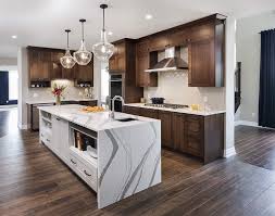 Stained kitchen cabinets will never go out of style (although certain stain colors may rise and fall in popularity). Bright Kitchen Medium Dark Wood Cabinets White Island Dark Brown Kitchen Cabinets Brown Kitchen Cabinets Dark Brown Cabinets