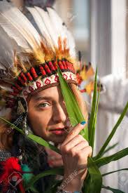 Indian Woman Hunter. Close-up Portrait Of Beautiful Woman In Native  American Costume With Feathers. Portrait Of A Beautiful Girl. Native  American, Indian Woman In Traditional Dress, Posing. Native American Woman  Shaman With