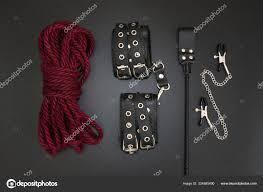 Leather handcuffs, shibari rope, nipple clamps and stack for bdsm games on  black background. Accessories for adult sexual game Stock Photo by ©luda311  324585490