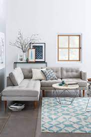 Wooden table next to grey corner settee in warm living room interior with painting and fireplace. How To Style A Room When You Have A Grey Sofa Houzz Au