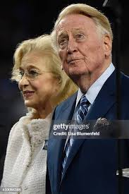 Vin Scully and his wife Sandra Hunt walk onto the field during a... News  Photo