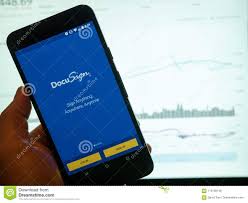 Docusign Mobile App Held In Front Of A Bright Stock Price