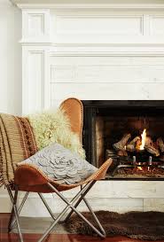 This modern butterfly chair takes on an old favorite, it has a woven canvas cover that is durable and lightweight. Modern Design Butterfly Chair In Front Of Fireplace In Living Room By Trinette Reed Stocksy United