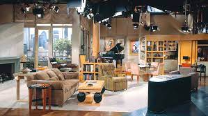 The angled polished stainless steel legs of the frasier coffee table create interest that you can see through a clear glass top. Frasier S Apartment Set Design Decor Scene Therapy