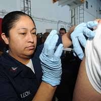 Dale Earnhardt Jr. signs an autograph for Aviation Boatswain's Mate  (Equipment) Airman Cody Nelson aboard the aircraft carrier USS Theodore  Roosevelt (CVN 71).