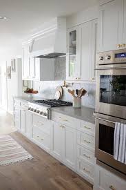 White shaker kitchen cabinets with brass hardware. Polished Brass Pulls On White Shaker Cabinetry Transitional Kitchen