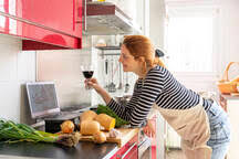 Whether it's for marketing, entertainment or quite often both, video is more popular than ever. Young Woman Havig A Video Chat While Cooking A Healthy Meal Stock Photo