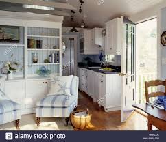 Gusseiserne pfannen oder kunstvoll verzierte kochlöffel kommen zum beispiel mit haken an die wand, edles porzellangeschirr schmückt offene küchenregale. Sessel Vor Der Anzeigeeinheit Im Landhausstil Offene Kuche Stockfotografie Alamy