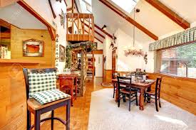 Also know, should floor and ceiling planks run same direction? Bright Kitchen And Dining Room In Log Cabin House High Vaulted Ceiling With Beams And Wooden Plank Wall Trim Blend Perfectly With Hardwood Floor And Rustic Furniture Stock Photo Picture And Royalty