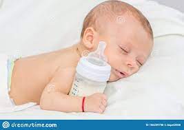 Baby Curled Up Sleeping On A Blanket With Feeding Bottle Stock Photo Image Of Drink Milk 156259790