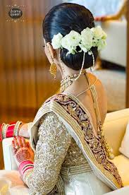 What A Beautiful Large Low Bun With Real Flowers Care However Should Be Taken Before With Images Indian Wedding Hairstyles Indian Bride Hairstyle Indian Bridal Hairstyles