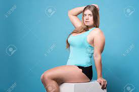 Being Sexy. Attractive Youthful Chubby Woman Sexy Posing While Sitting  Against Isolate Blue Background. Фотография, картинки, изображения и  сток-фотография без роялти. Image 68510087