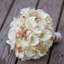 Xo bouquets seashell 21 inch bouquet plus one boutonnieres beach wedding. A Fun And Elegant Seashell And Starfish Bouquet Mix Of Our Signature Cream Soft Touch Roses Real Beach Wedding Colors Calla Lily Bouquet Wedding Beach Bouquet