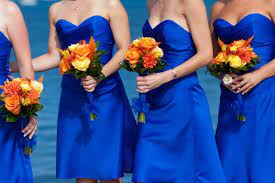 Brides can incorporate delphinium flowers into ceremony or reception arrangements as well as arm sheaf bouquets. Bridesmaids In Cobalt Blue With Orange Bouquets The Merry Bride