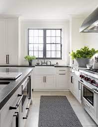 Simple white cabinets and clean silver hardware work well alongside wooden countertops and light colored wall paint. White Kitchen Cabinets With Black Hardware And Hinges Decorkeun