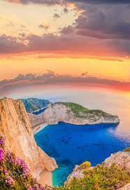 Navagio Beach With Shipwreck And Flowers Against Sunset Greece Landscape Beautiful Beaches Most Beautiful Beaches