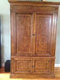 Versatile armoire by ethan allen painted with a floral pastel motif against off white background, having drawers inside and a dowel for hanging clothes. Ethan Allen Townhouse Entertainment Armoire Entertainment Armoire Townhouse Living Room Tall Cabinet Storage