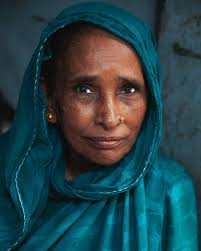 Portrait of a woman from Dhaka. She was selling bananas in a small alleyway  and caught my eye as her turquoise shawl matched the color of the interior  of her shop. It's
