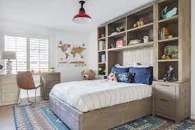 A shelf structure frames the bed in this fun and colorful bedroom display. Brown Oak Kid Bed Surrounded By Shelves Transitional Boy S Room