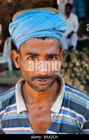 Portrait of a porter in Crawford Market (Mahatma Jyotiba Phule Market), a  wholesale fruit market in Mumbai, India, balancing his basket over his head  Stock Photo