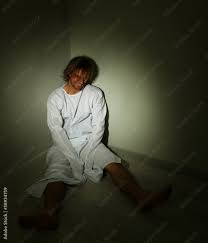 Mentally ill man in strait-jacket in room corner Stock Photo | Adobe Stock
