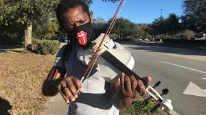 Violinist plays for motorists in Palm Coast. Some drivers show appreciation  with tips.