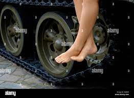 Girl with bare feet sitting on a tank Stock Photo - Alamy