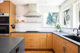 A mid century modern kitchen mixes minimalism with personality. Wood Cabinets White Counter To Ceiling Backsplash Tile From Tierrra Sol And Modern Black Kitchen Mid Century Modern Kitchen Cabinets Black Kitchen Countertops